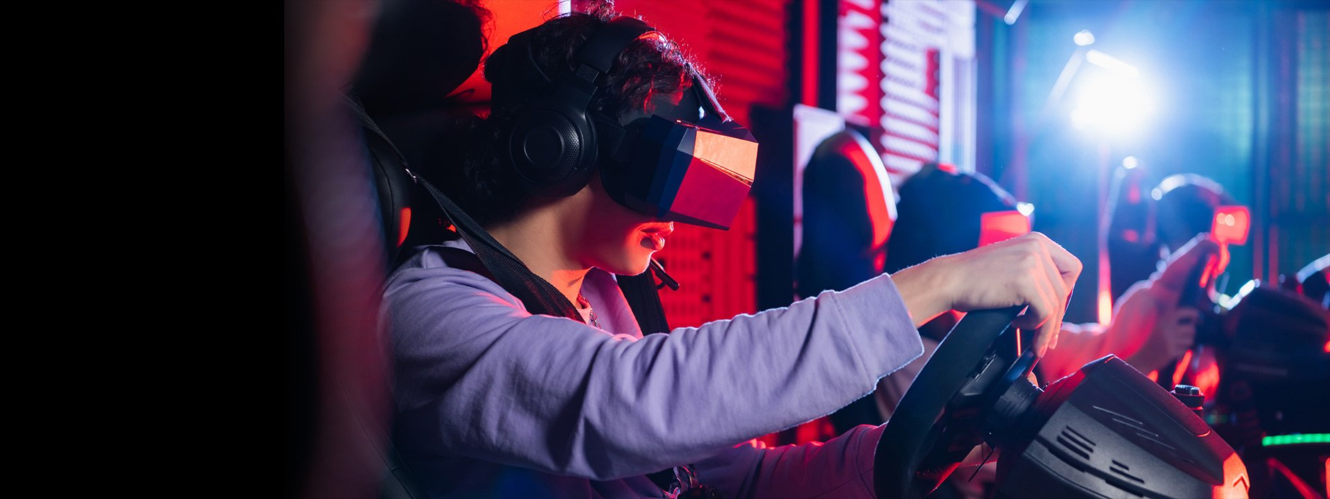 Teenage boy in VR headset playing racing game on car simulator