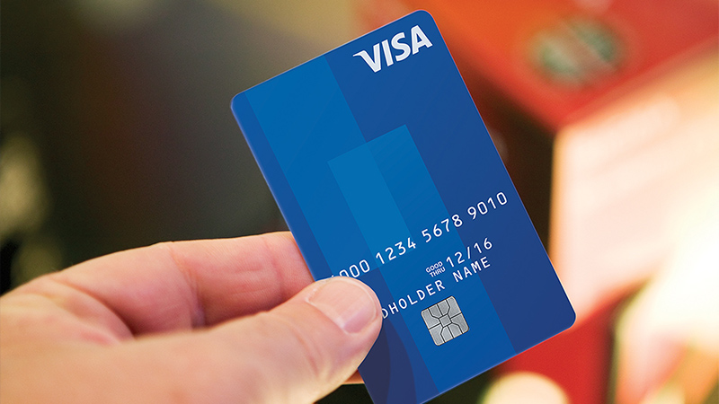 Person holding Visa chip card. Person holding Visa chip card.
