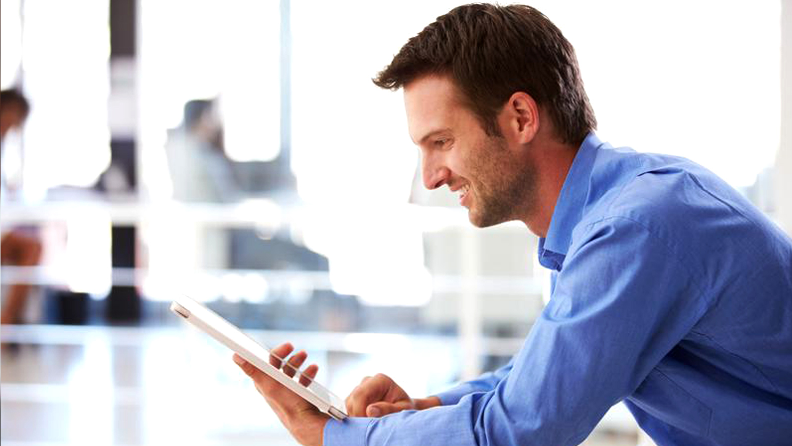 Man smiling at a tablet. Man smiling at a tablet.